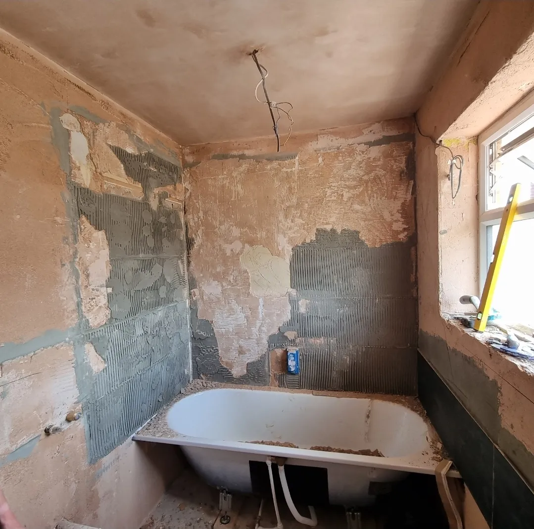 Bathroom stripped bare before renovation with old clawfoot bath — bathroom renovation contractors Surrey