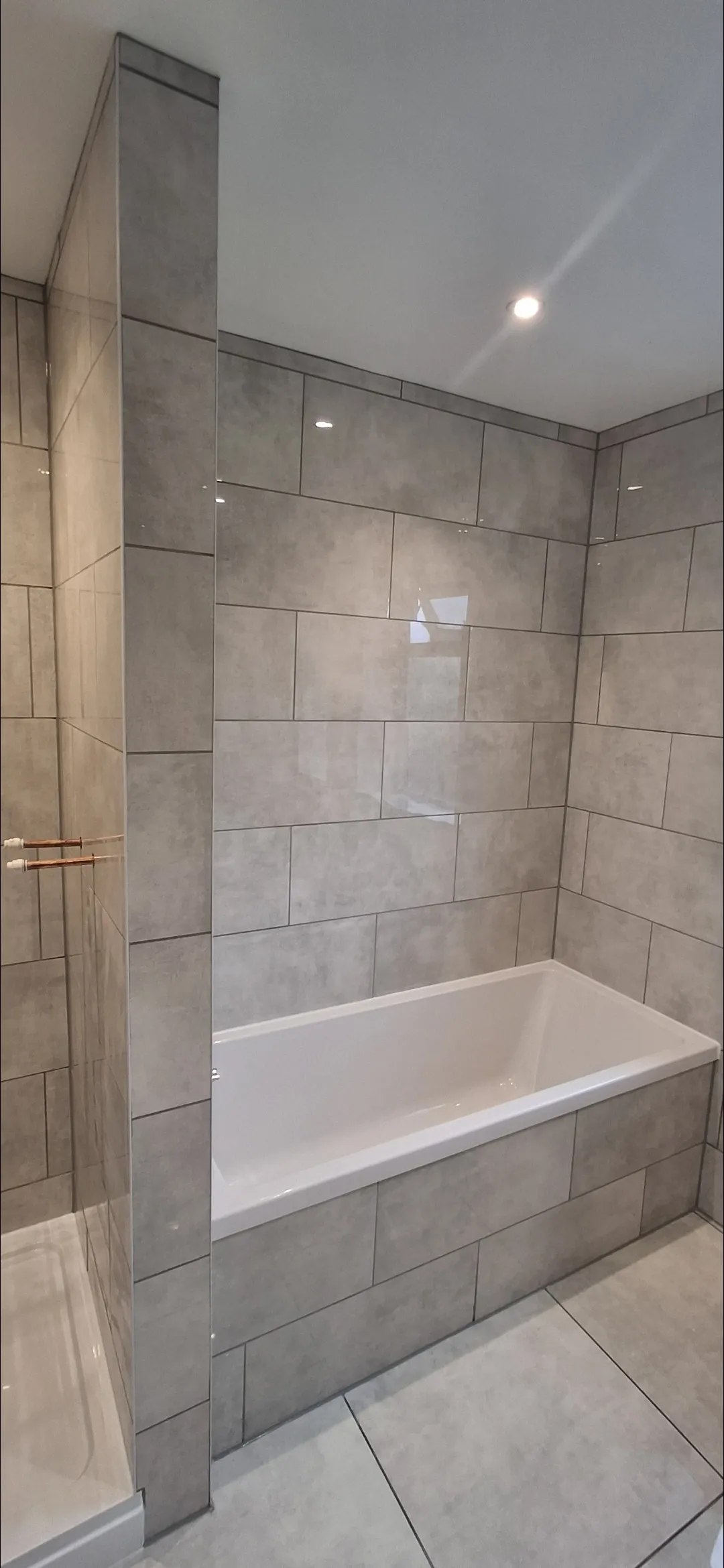 Bathroom large grey tile with bath and shower divider — bathroom renovation Surrey
