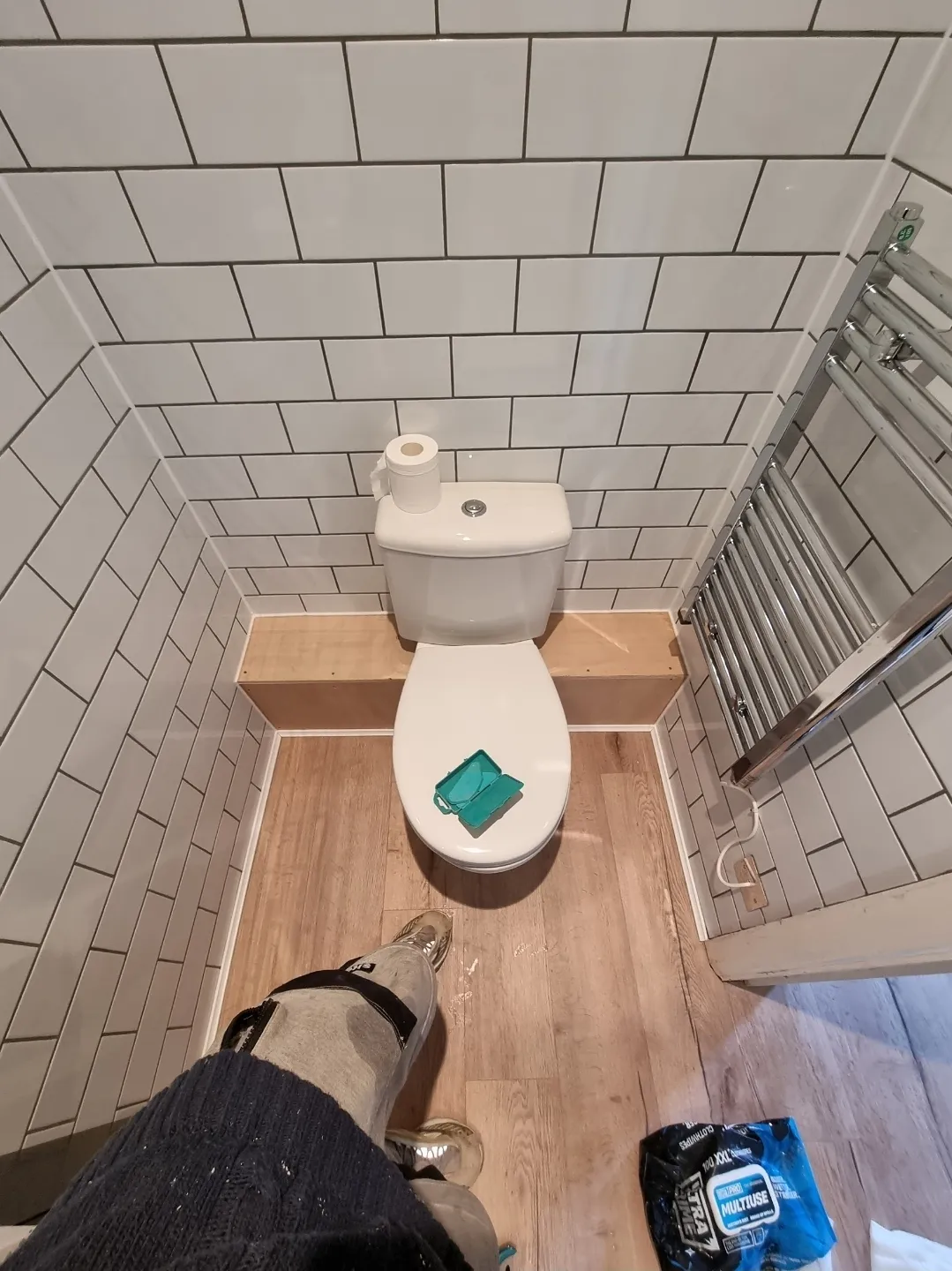 Bathroom white metro tile WC with chrome towel rail overhead view — bathroom fitters Surrey