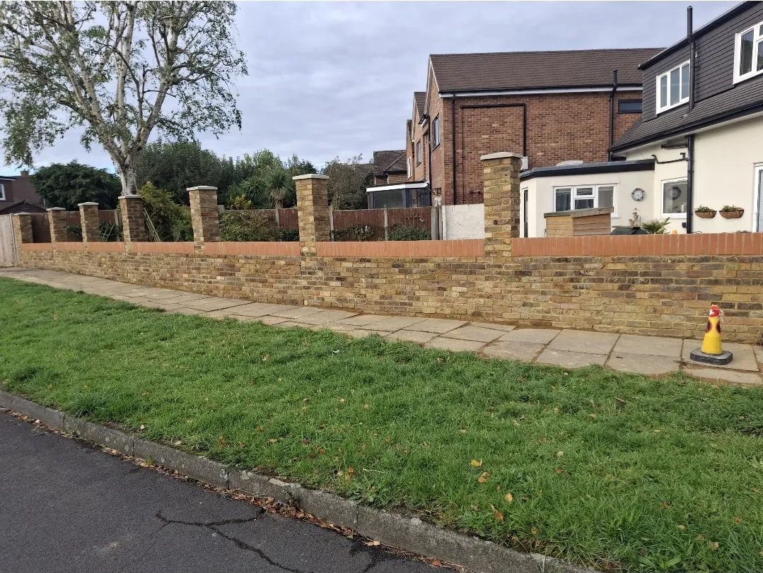 Brick boundary wall with piers and coping stones completed — builders Surrey