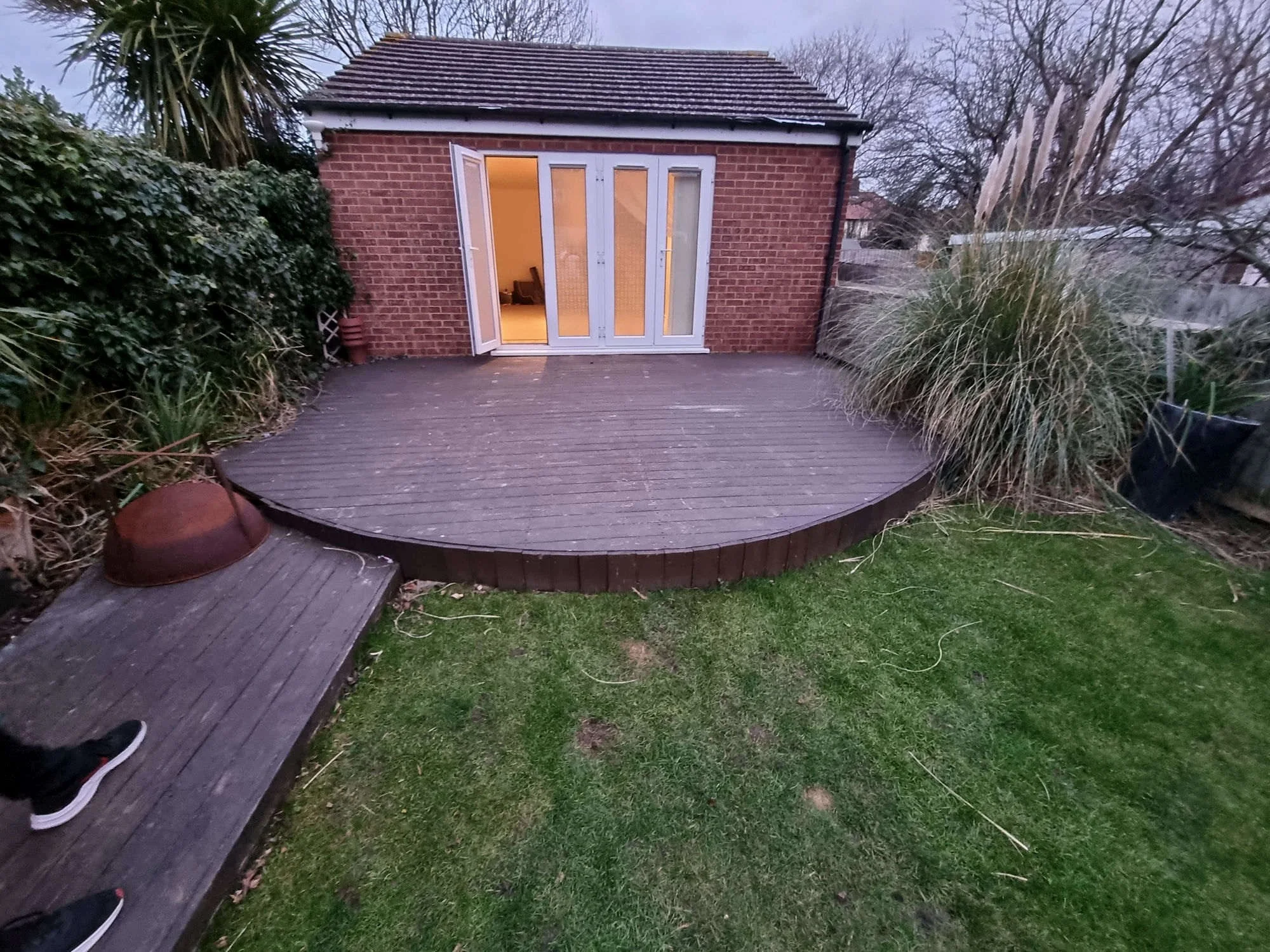 Old weathered curved decking before replacement — garden builders Hampton SW London