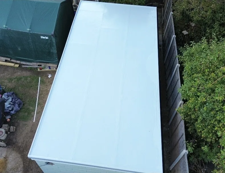 Fibreglass flat roof on white outbuilding aerial view — flat roof specialists Surrey