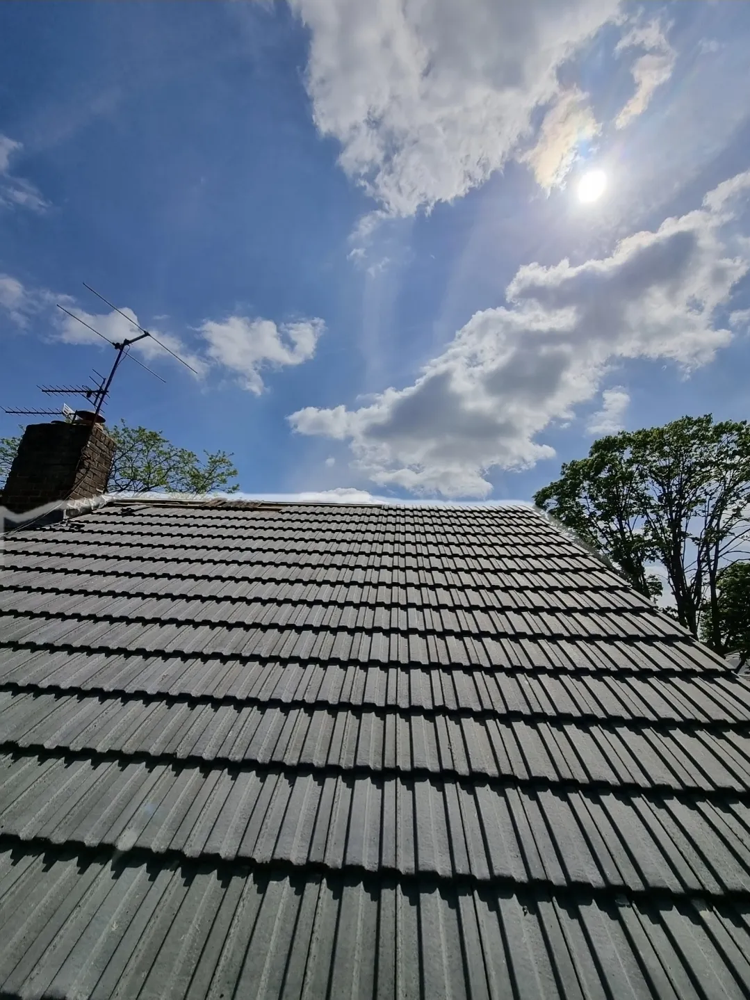Grey concrete tile roof replacement looking up — roofers Surrey
