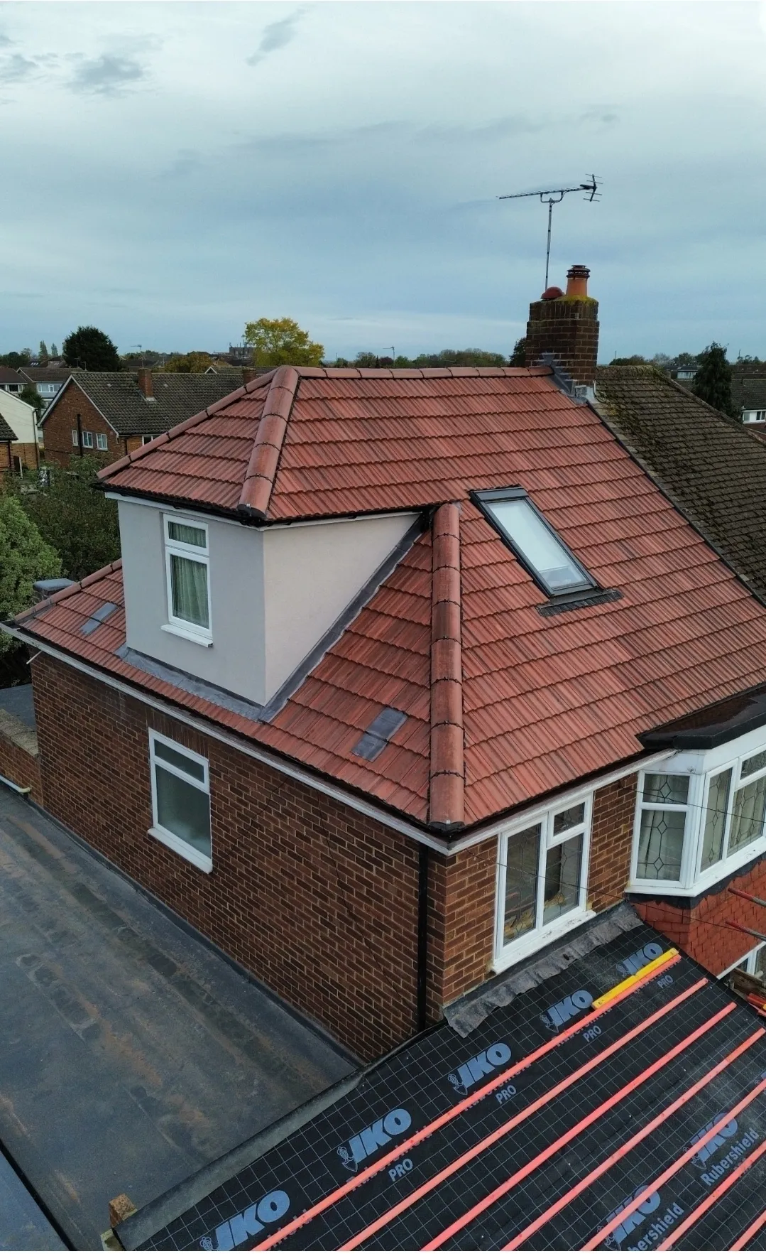 Pitched red tile dormer and Velux with IKO underlayment aerial — SW London roofers