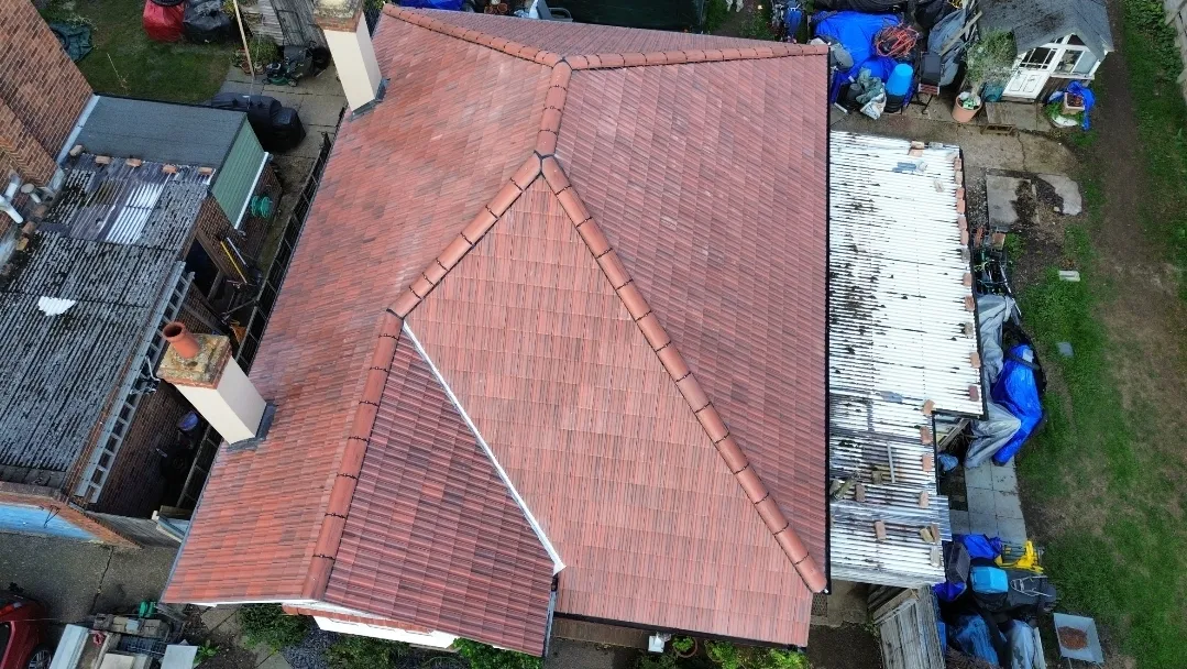 Pitched red tile hip roof completed aerial view — roofing contractors SW London