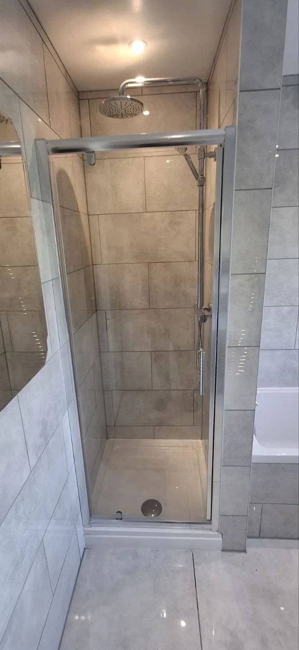 Shower enclosure tiling with rainfall shower head — bathroom tilers Surrey