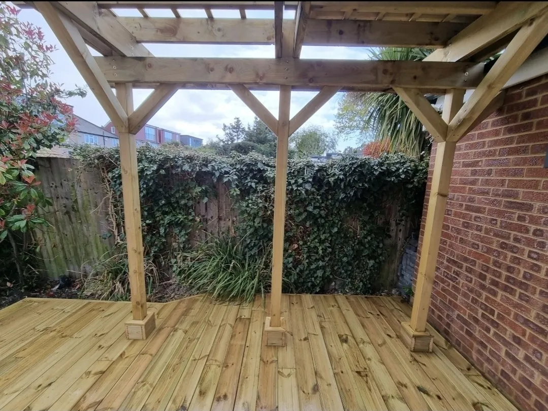 Timber pergola interior view with deck on brick house — decking contractors Surrey